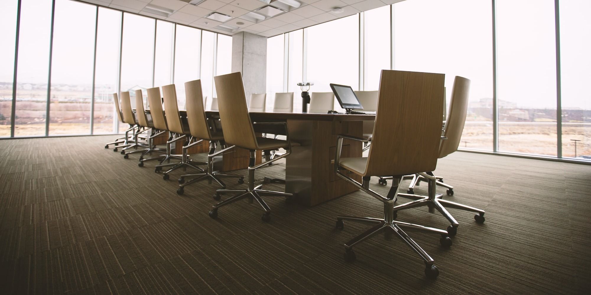 oval brown wooden conference table and chairs inside conference room