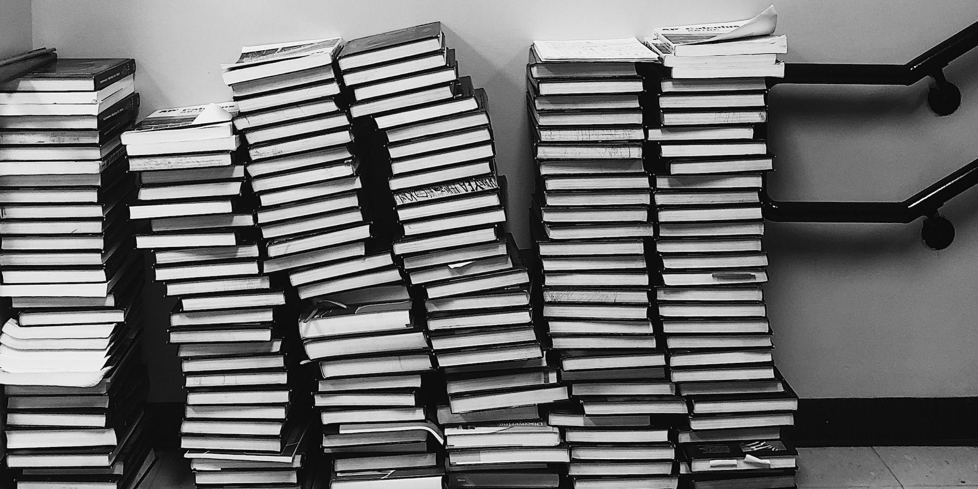 grayscale photography of pile of books